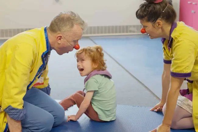 Smiling Clowndoctor with red nose looking playfully