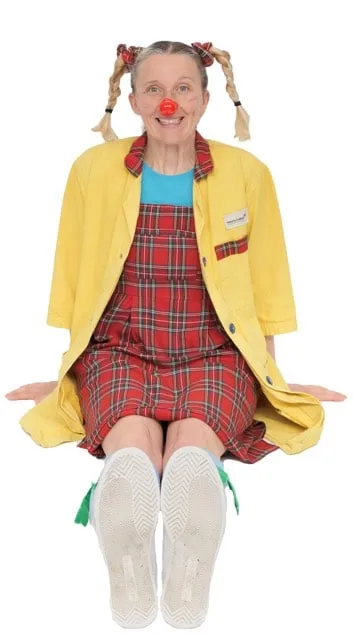 Dr Spritely seated cross-legged in yellow costume